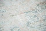 Faded blush and silvery grey geometric motifs on a distressed vintage Oushak carpet.