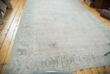 Distressed Heriz style Oushak carpet with faded blush field and grey-green motifs.