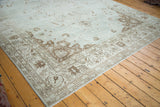 Distressed Oushak corner: soft sea foam green field, coffee bean chocolate border patterns.