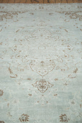 Softened sea foam green field and coffee bean brown motifs on a distressed Oushak rug.