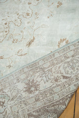 Distressed Oushak rug pile in softened seafoam green and coffee brown, with woven back.