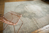 Distressed Oushak carpet with faded forest green field and intricate ivory floral patterns.