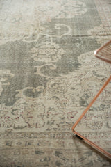 Distressed Oushak carpet with faded forest green field and intricate ivory floral pattern.