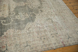 Softened forest green field with faded beige floral patterns on distressed Oushak rug.