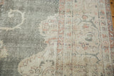Distressed Oushak rug detail: faded forest green field with intricate ivory and blush floral motifs.