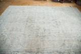Distressed Oushak rug showcasing blanched ivory, beige, and grey field with faded medallion.
