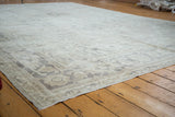 Distressed Oushak carpet texture with blanched ivory, silver, and muted grey tones.