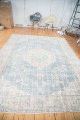 Faded slate blue Oushak rug border with distressed ivory and peach floral motifs.