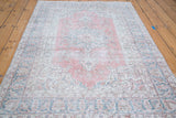 Vintage distressed Oushak rug, faded raspberry red field with ivory and deep sky blue motifs.