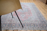Distressed Oushak rug with faded raspberry field, ivory and deep sky blue curvilinear patterns.