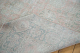 Distressed Oushak rug folded, revealing sun-faded rose blush pile and tightly woven foundation.