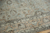 Distressed Oushak carpet with faded silver, peachy lotus patterns, and a dark border.