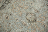 Distressed Oushak carpet section with faded silver platinum field, peachy lotus pattern, and dark border.