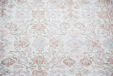 Distressed Oushak carpet texture with faded blush, ivory, and soft green germinating flowers.