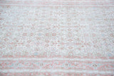 Distressed blush red and ivory germinating flower motifs on a hand-knotted Oushak rug.