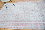 Distressed Oushak rug detail showing intricate weave, germinating flowers, and faded border.