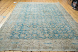 Distressed texture of the teal blue Oushak rug with its faded beige border.