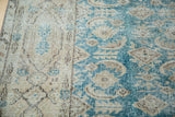 Distressed hand-knotted Oushak rug with faded teal field and beige border.