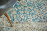 Distressed hand knotted Oushak carpet with decorative allover teal pattern and faded beige border.