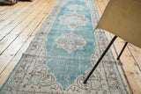 Distressed aqua blue field and ornate ivory medallion on a vintage Oushak runner.