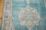 Detail of ornate Oushak medallion with distressed aqua blue and pastel blush.