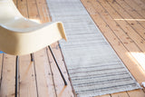 Distressed Oushak runner displaying horizontal stripes in neutral tones and textured raw edge.