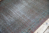 Distressed, overdyed vintage runner pile with a geometric border in muted teal and burgundy.