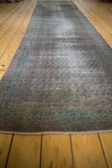 Distressed overdyed vintage runner with muted teal geometric border and fringe.