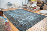 Striking contrast on overdyed carpet, showing geometric tribal patterns in sky blue and charcoal.