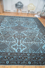 Charcoal black tribal geometric pattern contrasting dense sky blue on an Afghani overdyed rug.