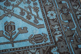 Dense sky blue and charcoal black geometric tribal patterns on an Afghani overdyed rug.