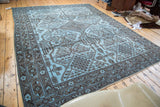 Light sky blue overdyed rug with dramatic charcoal geometric and tribal motifs.