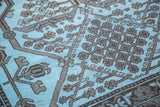 Intricate charcoal geometric and tribal patterns on light sky blue hand-knotted overdyed carpet.