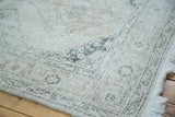 Distressed Turkish Sparta runner corner, blanched ivory, beige, charcoal pattern, and frayed fringe.