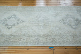 Faded ivory, beige, and charcoal lattice medallion pattern on a distressed Sparta runner.
