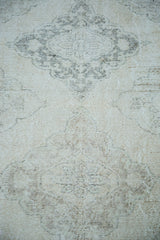 Close-up of distressed hand-knotted pile, showing blanched ivory, beige, and charcoal patterns.