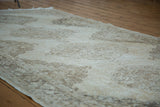Distressed Sparta runner's textured pile, showing faded ivory and coffee bronze medallion pattern.