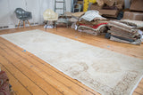 Faded quintuplet medallions on a distressed Turkish Sparta runner in soft ivory and beige.