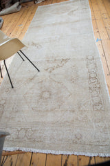 Fringed end of distressed vintage Turkish Sparta runner with muted patterns.
