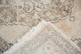 Distressed ivory and beige pile, revealing hand-knotted foundation of vintage Sparta rug.