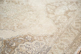 Close-up of distressed hand knotted pile with fading ivory and coffee bronze lattice patterns.