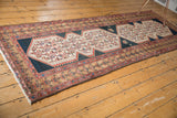 Geometric double medallion and stylized motifs on the distressed Malayer runner's navy field.