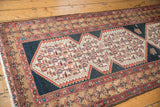 Distressed fringe and corner of the Malayer runner with intricate geometric patterns in faded red and beige.