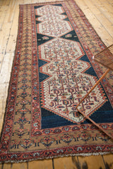 Distressed Malayer runner with geometric patterns, faded red, and light bronze border.