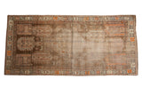 Distressed Caucasian runner with brown field, geometric diamond medallion, and orange accents, 3'8