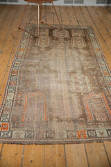Distressed vintage Caucasian runner rug with faded brown, tangerine, and ivory geometric motifs.