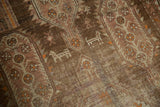 Distressed pile of Caucasian runner, revealing geometric animal forms in brown and orange.
