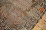 Distressed geometric border of a vintage Caucasian runner, featuring tangerine orange details.