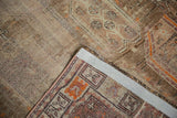 Distressed geometric patterns, brown, beige, orange, revealing woven backing of runner.
