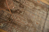 Distressed Caucasian runner showing geometric border and field patterns in coffee, ivory, and orange.